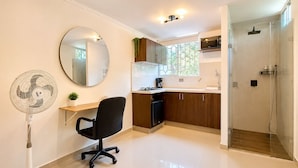 Una cocina moderna con comedor, ventilador y ducha a pie.