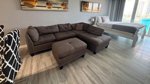 En moderne stue med en modulsofa, en seng og kunst på væggene.
