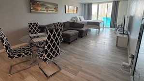 En moderne stue med sofa, spisebord med stole og seng.