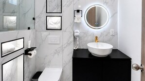 A modern bathroom with a toilet, sink, and mirror. - Standard plus room 207 9 minutes from Val'Quirico (Tetlatlahuca)