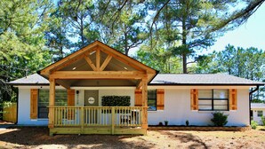 A single-story house with a wooden porch, a small front yard, and a clear sky. - Family-Friendly Covington Escape w/ Fenced Backyard, Full Kitchen & Coffee Bar (Covington)