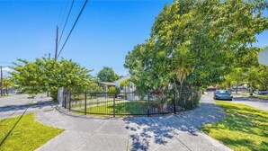 A residential property with a fenced yard, a driveway, and a street view. - Fantastic 1-bedroom townhome with AC in vibrant Miami (Miami)