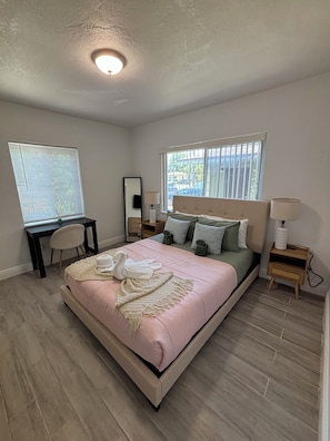A bedroom with a bed, desk, chair, bedside tables, and a window. - Fantastic 1-bedroom townhome with AC in vibrant Miami (Miami)