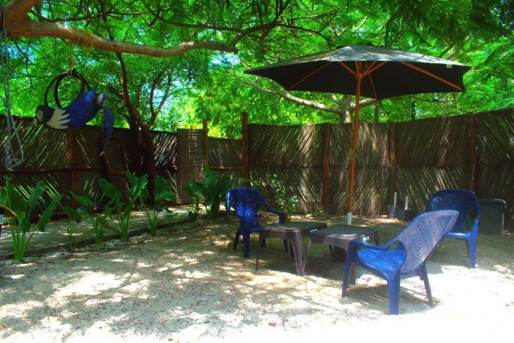 Un'area patio esterna con tavolo, sedie e ombrellone.