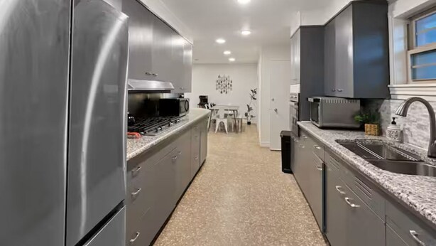 A modern kitchen with stainless steel appliances, granite countertops, and a central island.