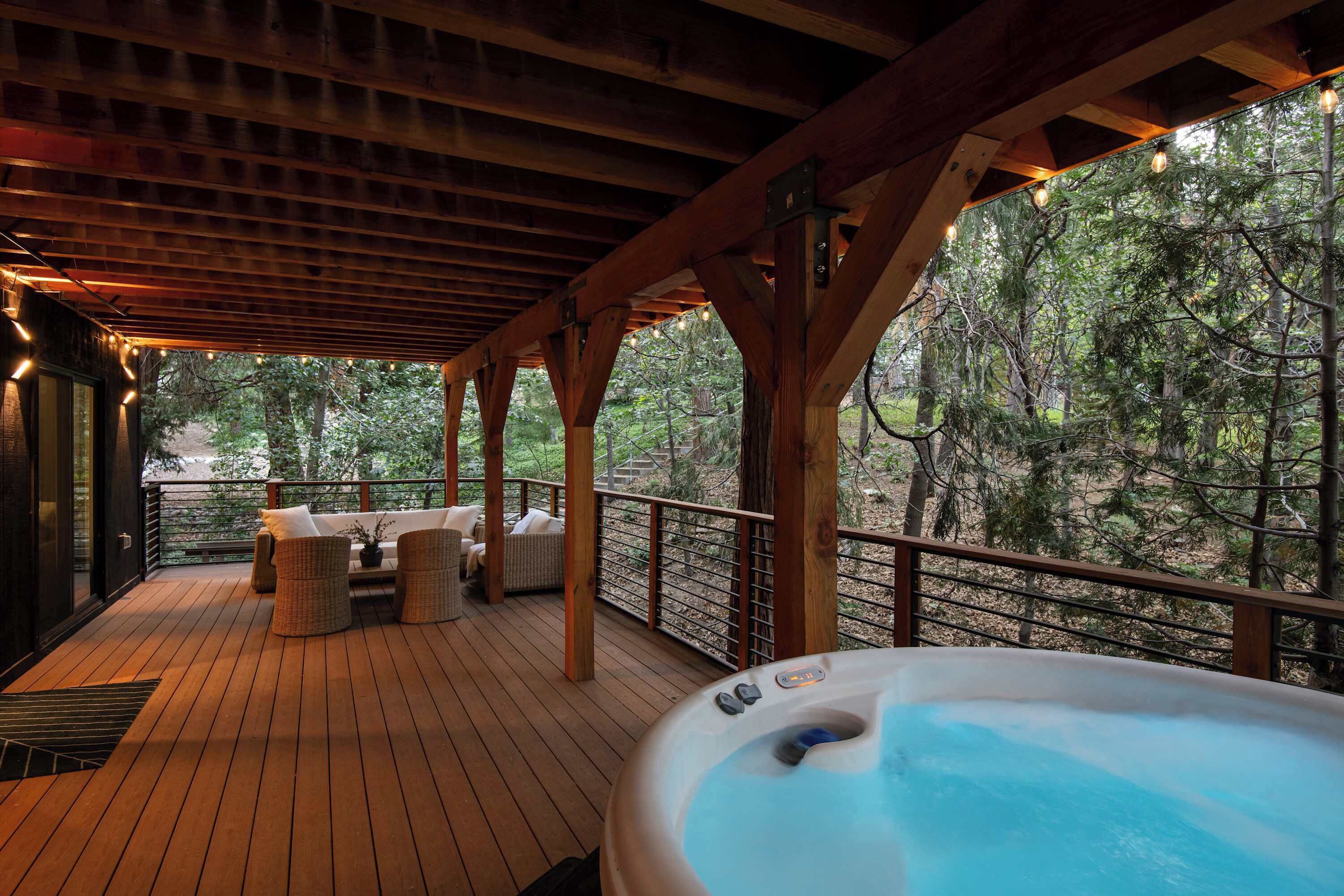 Une terrasse en bois avec des sièges d’extérieur et un jacuzzi.