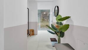 Een modern interieur met een groot raam, een plant en een bankje.