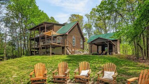 Une cabane dotée d’une terrasse, d’un foyer extérieur et de trois fauteuils Adirondack.