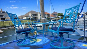 A boat with two turquoise rocking chairs and a blue floor design. - Sleep in a Van Gogh painting! A floating tribute to the art of Vincent. (League City)