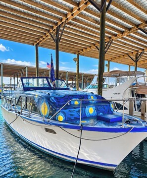 A boat docked under a covered area with a clear sky.