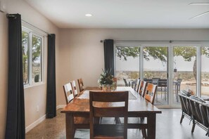 Long dining table beside the sliders - Pipes Canyon Retreat · 2 Homes, 10 Acres, Hot Tubs (Yucca Valley)