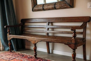 Carved wooden bench below a mirror - Pipes Canyon Retreat · 2 Homes, 10 Acres, Hot Tubs (Yucca Valley)