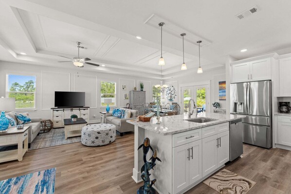 A modern kitchen with white cabinetry, stainless steel appliances, and a central island.