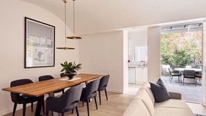 A modern dining area with a wooden table, black chairs, and a potted plant. - Ivy Terrace, Annandale IH (Annandale)