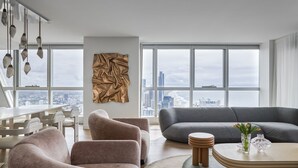 En moderne stue med byudsigt, spiseområde og et stort vindue.