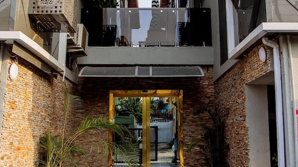 A modern building with a central entrance, air conditioning units, and potted plants. - The Luxe Stay, 2 Bed Room Apartment (Lagos)