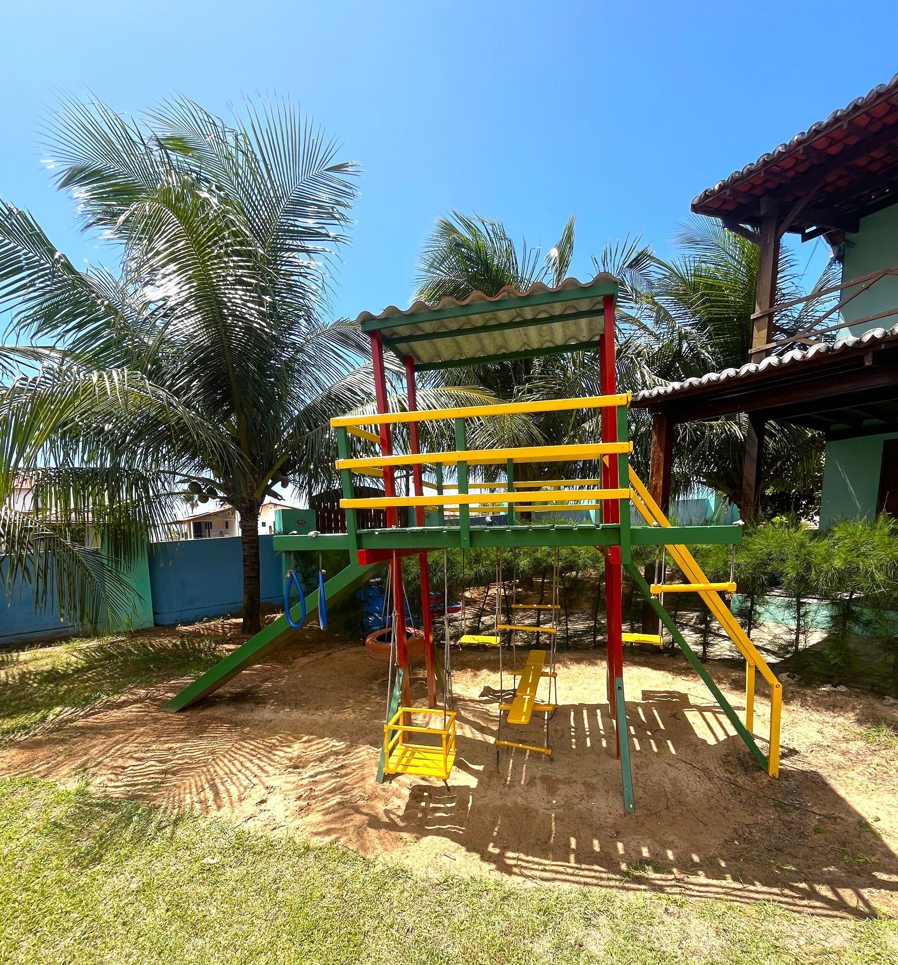 Ein Spielplatz mit Klettergerüst, Schaukeln und Rutsche.
