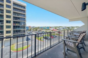 Ein Balkon mit Blick auf einen Parkplatz und Gebäude.