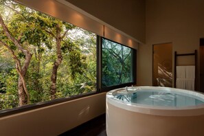 Ein Badezimmer mit großem Fenster, einer Badewanne und einem Handtuchhalter.