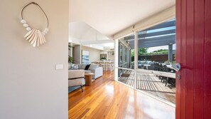 Ein modernes Interieur mit Holzboden, einer Couch und einem Essbereich.