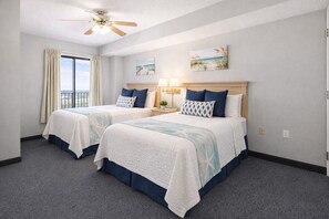 A hotel room with two beds, a ceiling fan, a view of the ocean, and artwork on the walls. - Cozy 3-bedroom condo with Ocean view and AC in delightful Myrtle Beach (Myrtle Beach)