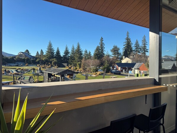Un balcone con vista su un parco, un edificio e una montagna.