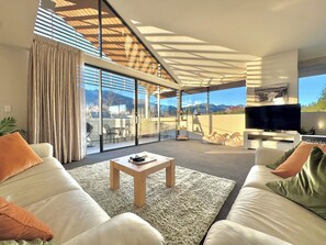 A modern living room with a sofa, coffee table, and a TV. - Luxury Corner Apartment In Central Hanmer
Springs. (Hanmer Springs)