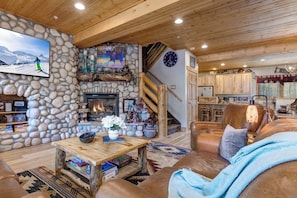 Ein gemütliches Interieur mit Kamin aus Stein, Holzbalkendecke und einer Steinwand.