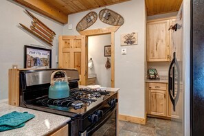 A kitchen with a gas stove, a kettle, wooden cabinets, and a refrigerator. - KBM Resorts | Timber Wolf Lodge | Mountain Elegance with Gas Fireplace, Common Hot Tubs, Near Canyons Village! TWL-5b (Park City)