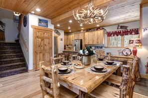 A rustic wooden dining area with a chandelier, wooden chairs, and a table set for four. - KBM Resorts | Timber Wolf Lodge | Mountain Elegance with Gas Fireplace, Common Hot Tubs, Near Canyons Village! TWL-5b (Park City)