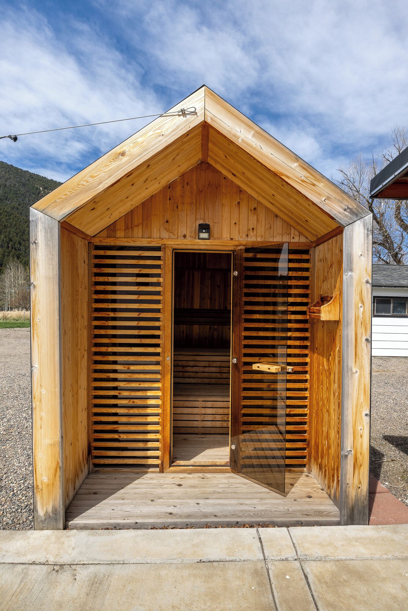 Une structure en bois dotée d’une porte à lattes et d’une petite fenêtre, posée sur une base en béton.