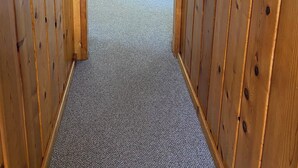 Un interior de madera con un banco, un reloj y una ventana.