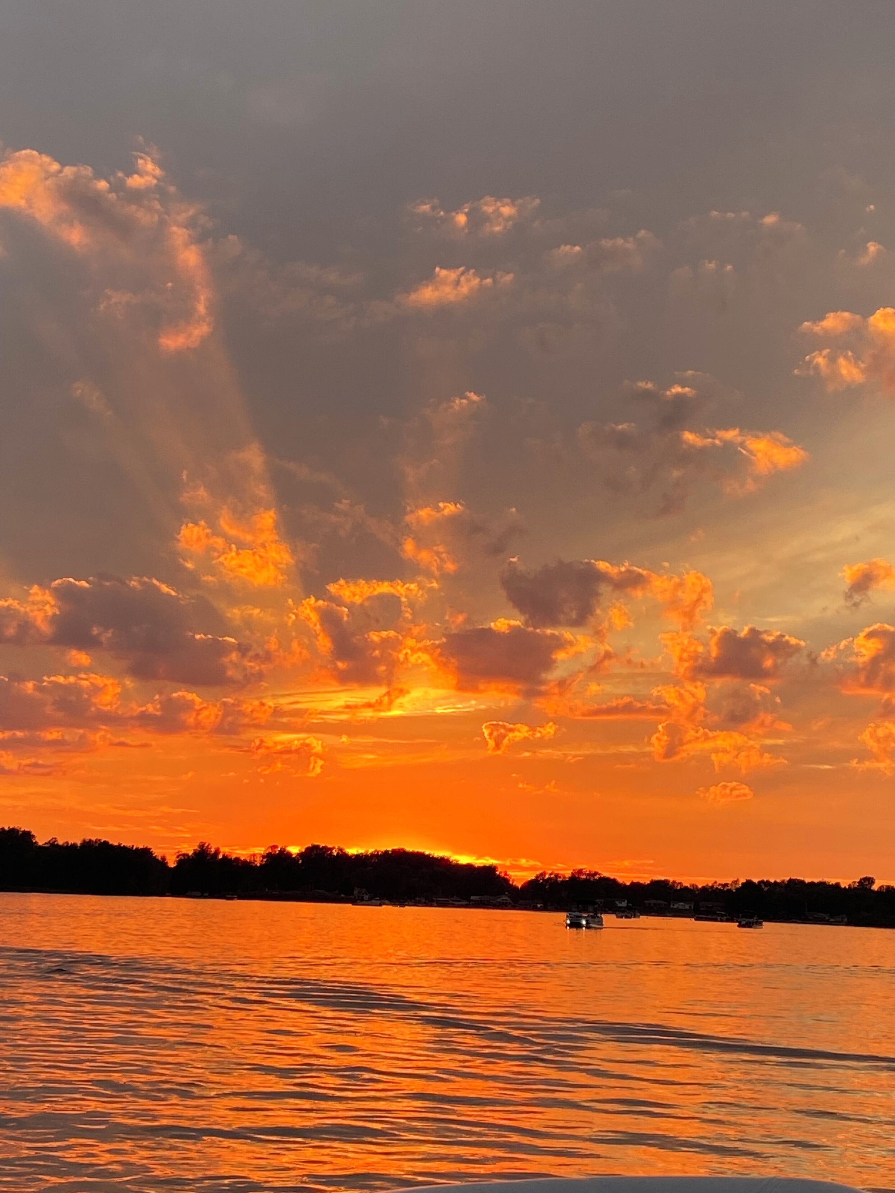 A sunset over a body of water with clouds in the sky.