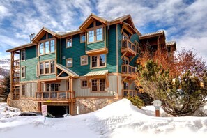 A multi-story lodge with a stone foundation, large windows, and a prominent entrance. - KBM Resorts | Town Pointe | Spacious 1 level, Walk to Main and Town Lift, Private Hot Tub, Parking, Elevator Access, A/C! TPC-102c (Park City)