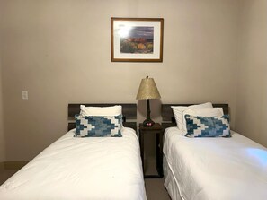 A hotel room with two beds, each with a patterned pillow, a nightstand with a lamp, and a framed picture on the wall. - KBM Resorts | Town Pointe | Spacious 1 level, Walk to Main and Town Lift, Private Hot Tub, Parking, Elevator Access, A/C! TPC-102c (Park City)