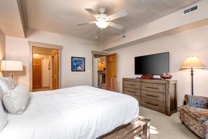 A bedroom with a bed, a ceiling fan, a dresser, a television, and a lamp. - KBM Resorts | Town Pointe | Spacious 1 level, Walk to Main and Town Lift, Private Hot Tub, Parking, Elevator Access, A/C! TPC-102c (Park City)