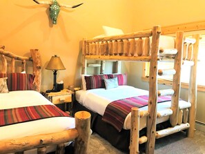 A rustic room with two bunk beds, a wooden headboard, a lamp, and a wall-mounted decorative item. - KBM Resorts | Timber Wolf Lodge | Walk to Canyons Cabriolet, Fireplace, BBQ, Aspens and Creek, Parking! TWL-12c (Park City)