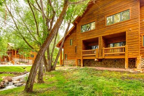 A log cabin with a stone foundation, multiple windows, and a porch. - KBM Resorts | Timber Wolf Lodge | Walk to Canyons Cabriolet, Fireplace, BBQ, Aspens and Creek, Parking! TWL-12c (Park City)