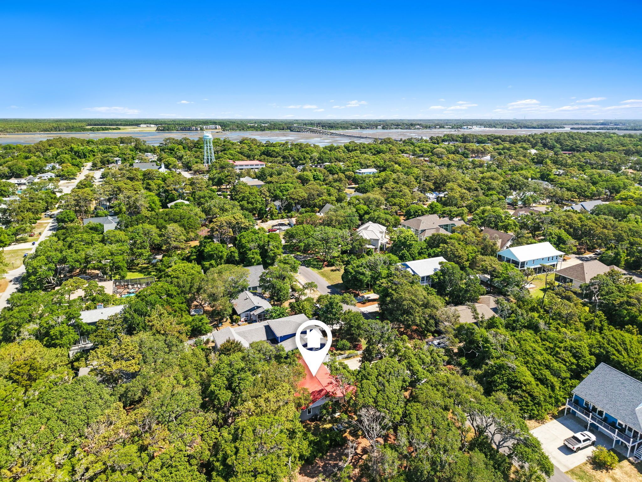An aerial view of a residential area with houses, a water tower, and a bridge.