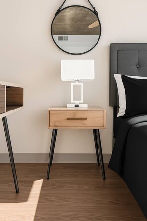A modern bedroom with a bed, bedside table, lamp, and a round mirror. - Bright + Airy Studio | Perfect City Escape 15 (Birmingham)
