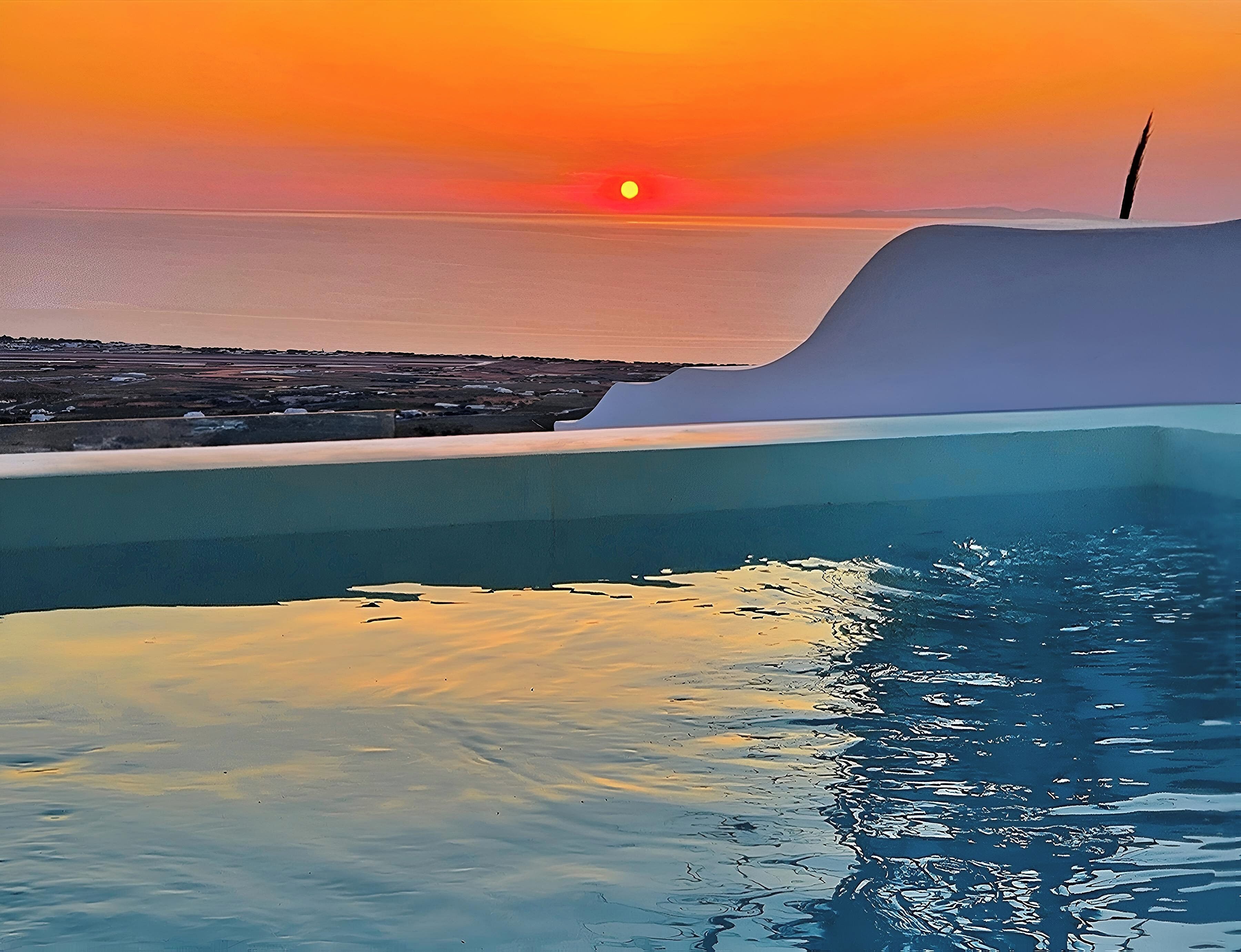 Een zonsondergang boven een wateroppervlak, met een heldere lucht, een grote golf en een constructie die in het water reikt.