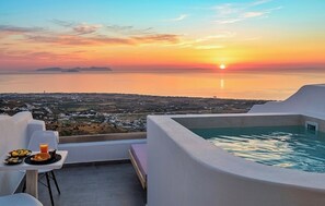 A rooftop terrace with a pool, dining table, and chairs, overlooking a coastal landscape during sunset. - Martynou View (Santorini)