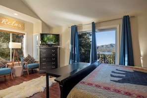A bedroom with a bed, a dresser, a TV, and a view of the outdoors. - Lakeview Lodge,HotTub, FirePit, BBQ, firework view (Big Bear Lake)