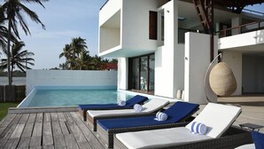 Un espace moderne aménagé au bord de la piscine, avec des chaises longues et une vue dégagée sur la piscine.