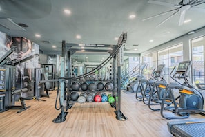 Una palestra con attrezzature per esercizi, macchinari per sollevamento pesi e tapis roulant.