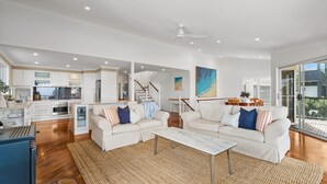 A modern living area with a kitchen, two sofas, a coffee table, and a dining area. - Copa Panorama House Stay (Copacabana)