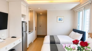A hotel room with a bed, bedside table, and a small kitchenette. - Gangneung Top Ocean (Gangneung)