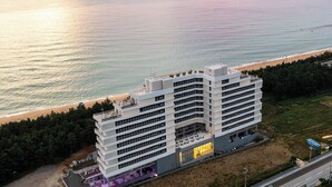 A multi-story hotel with a flat roof, located near a beach and ocean. - Gangneung Top Ocean (Gangneung)