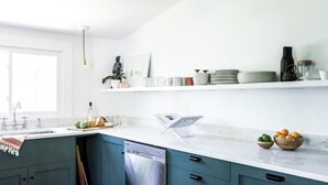 Une cuisine moderne équipée d’un lave-vaisselle, d’un évier et d’une fenêtre.