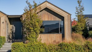 Una moderna casa in legno con un'ampia finestra e un basculante.